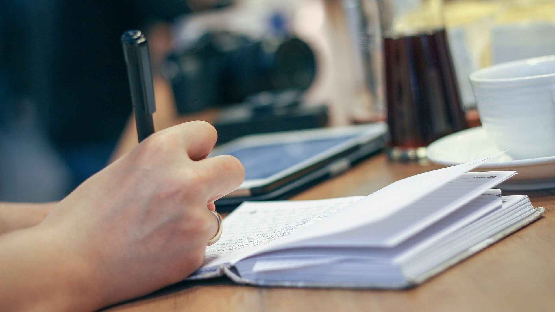 Symbolbild: Person schreibt in ein Notizbuch