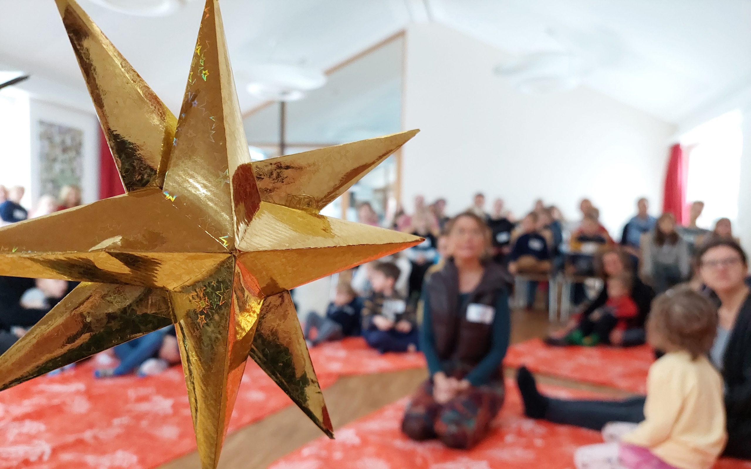Kirche Kunterbunt im Advent. Gruppenbild während der Feierzeit mit Weihnachtsstern im Vordergrund.